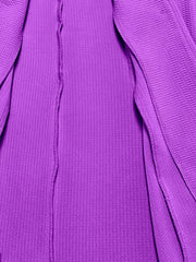Purple blazer with textured fabric and a single button closure.