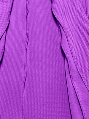 Purple blazer with textured fabric and a single button closure.