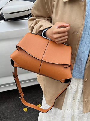 Brown textured geometric flap shoulder bag with adjustable strap.