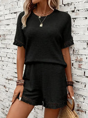 Black textured knit set with fringe detail on short sleeves and hem.