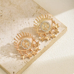 Gold evil eye star dangle earrings with crystal accents.