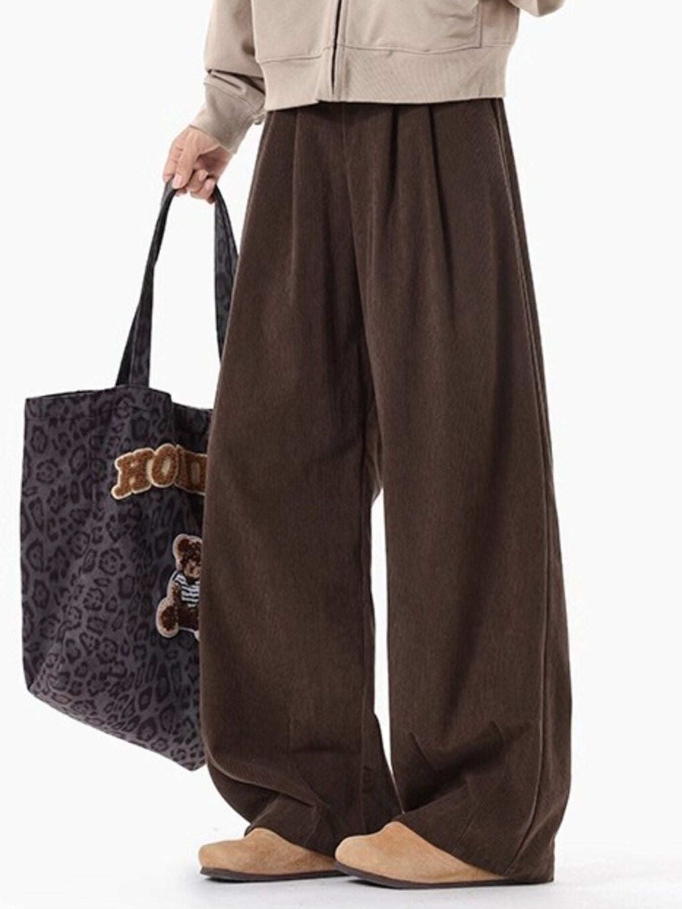Men's brown pleated wide leg trousers with a relaxed fit