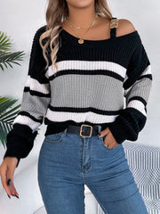 Asymmetric stripe knit sweater with gold shoulder detail, black, white, and gray stripes.