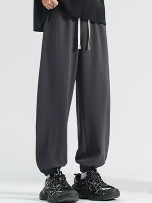 Men's dark gray loose fit sweatpants with drawstring and cuffed ankles