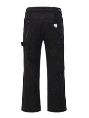 Black carpenter trousers with white paint splatters and distressed detail.