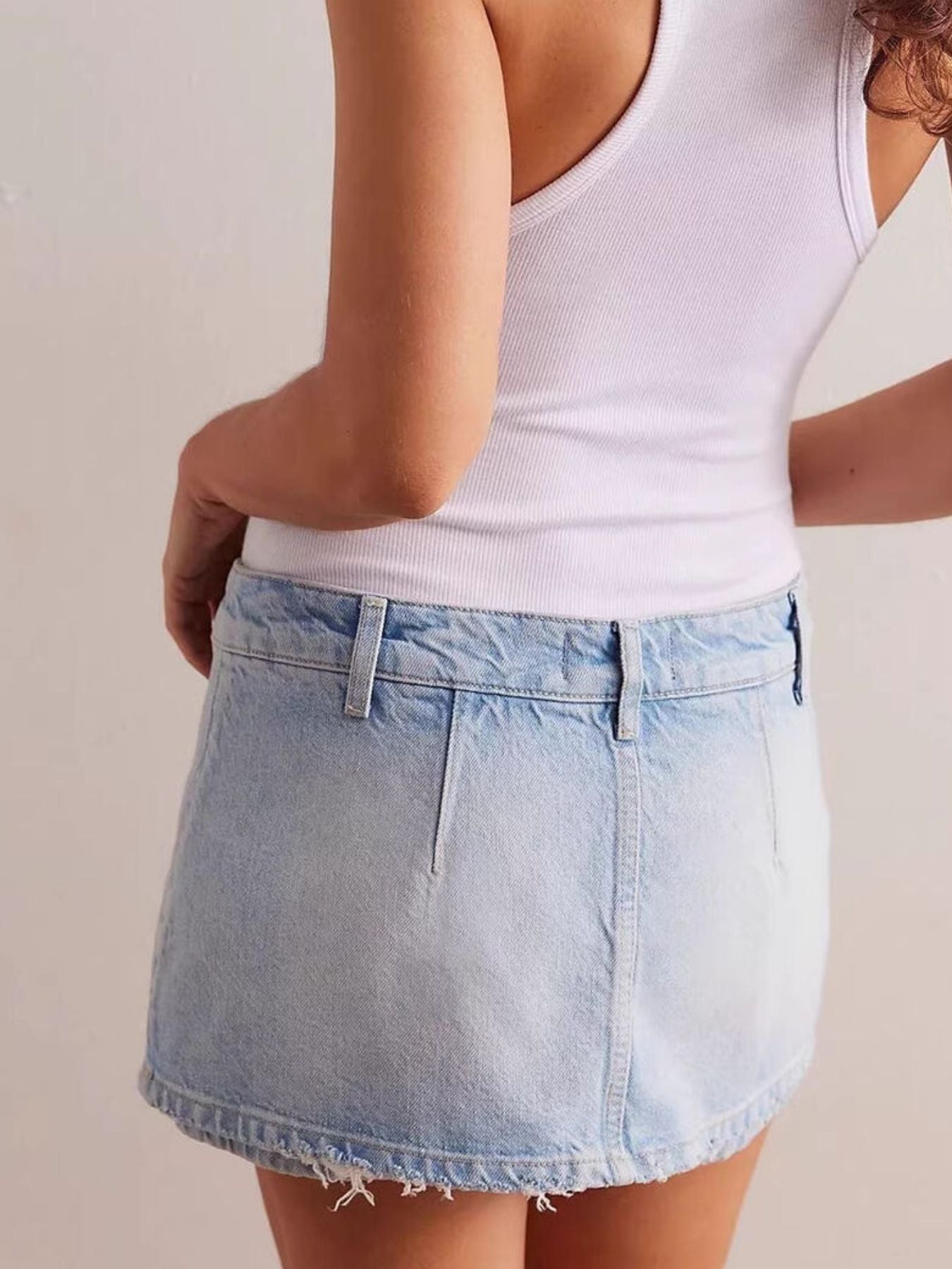 Light blue denim mini skort with button closure and frayed hem.