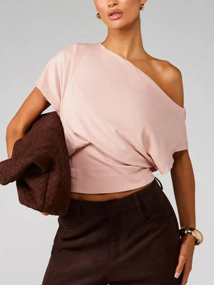 Pink asymmetrical crop t-shirt with draped fit and short sleeves.