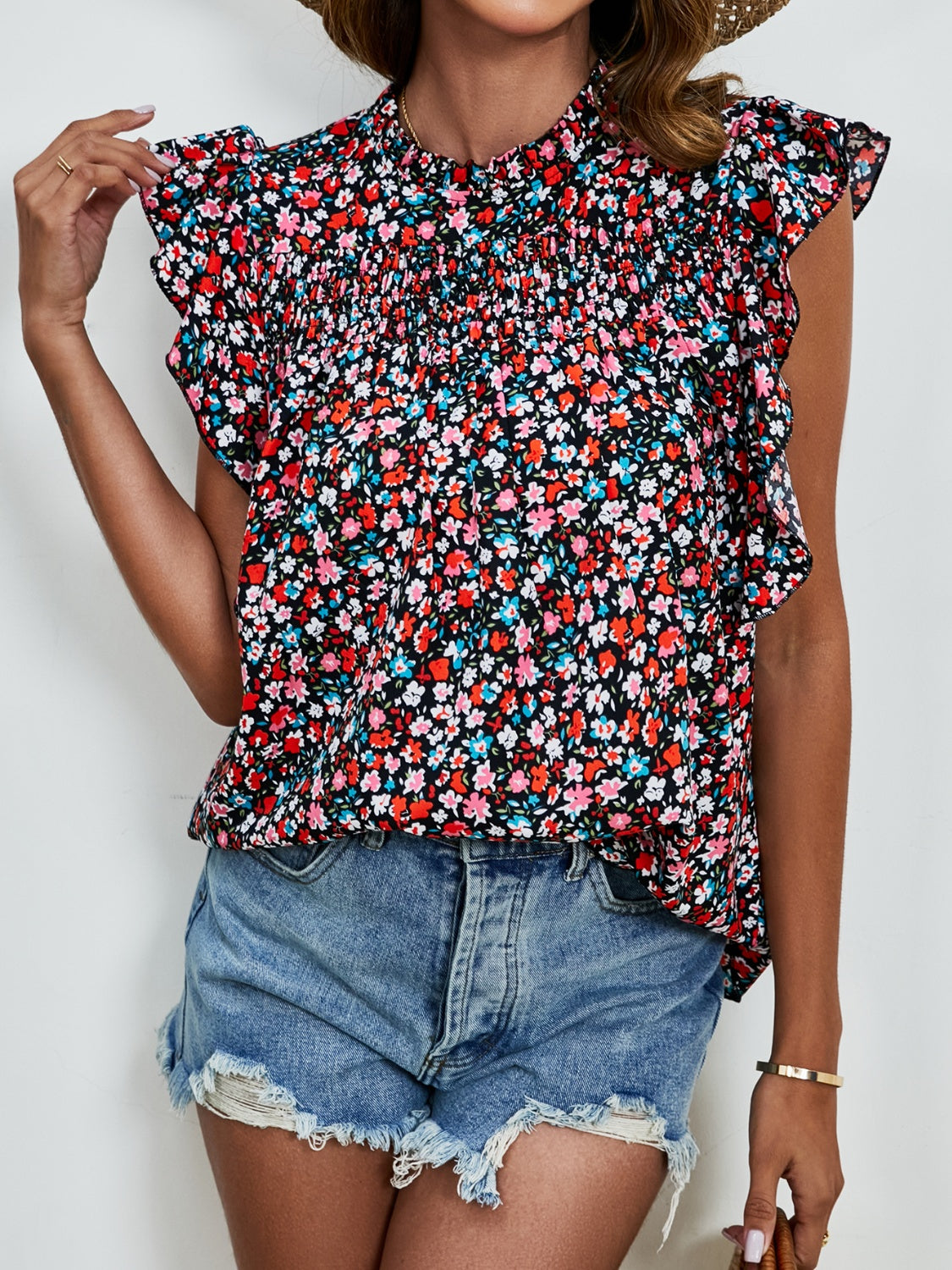 Smocked yoke ruffle sleeve floral blouse with high neck and short sleeves.