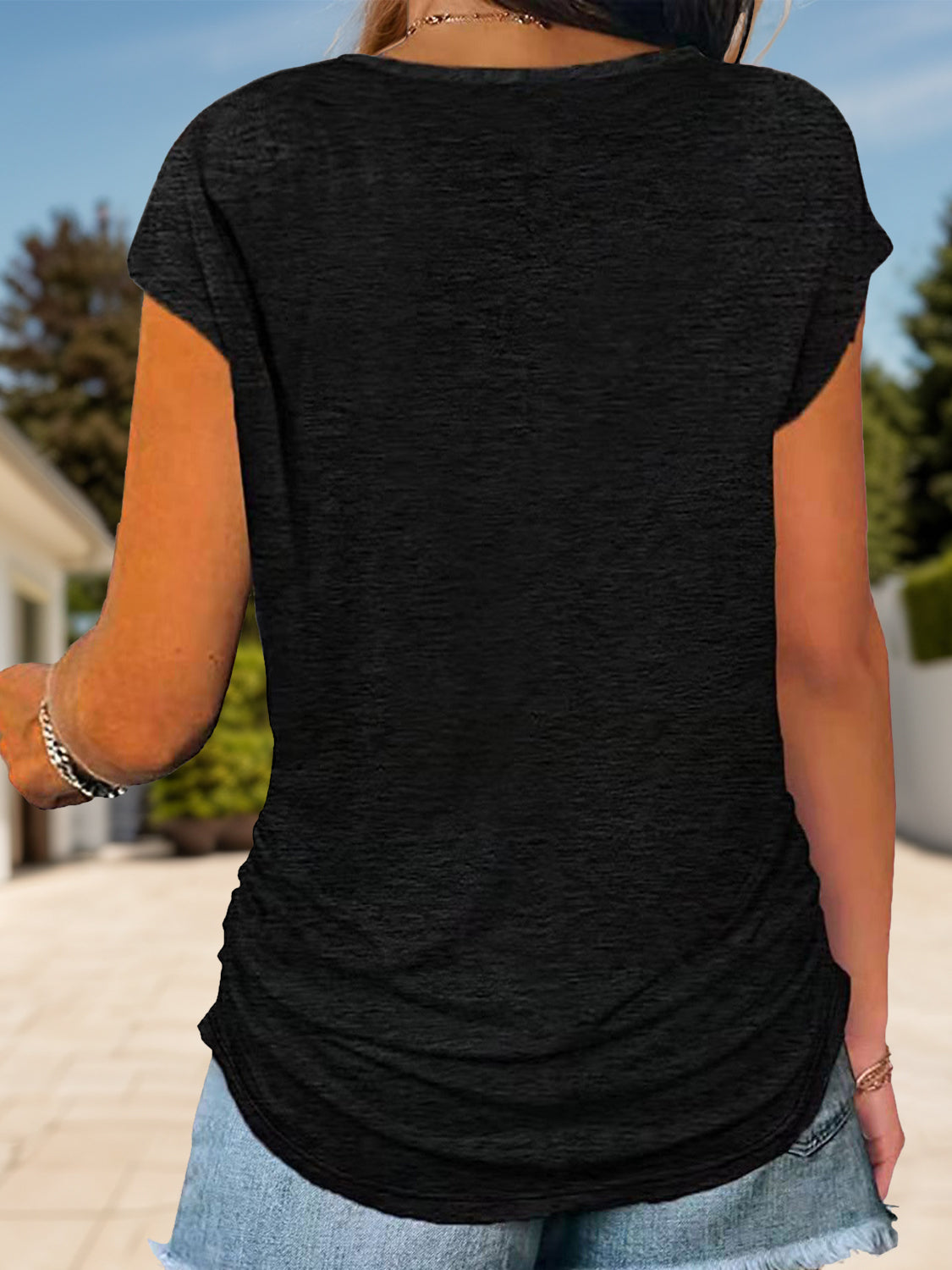 Black cap-sleeve tee with ruched sides and a curved hem