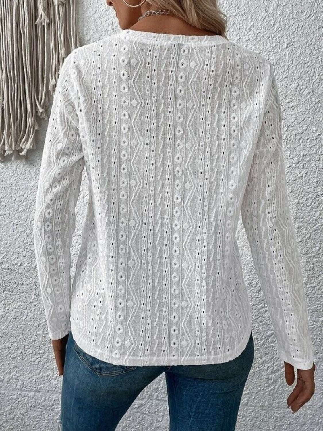 White eyelet long sleeve knit top with geometric pattern detail.