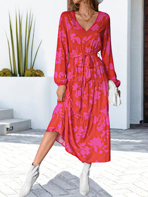 Tiered floral midi dress in hot pink and red with a tie waist and V-neck.