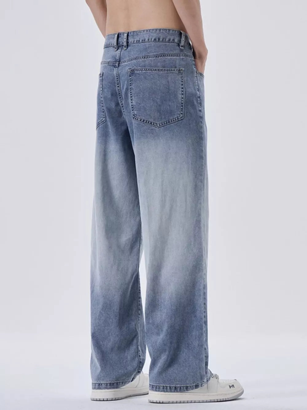 Relaxed fit men's sweatpants in light blue with vintage wash and gradient effect.