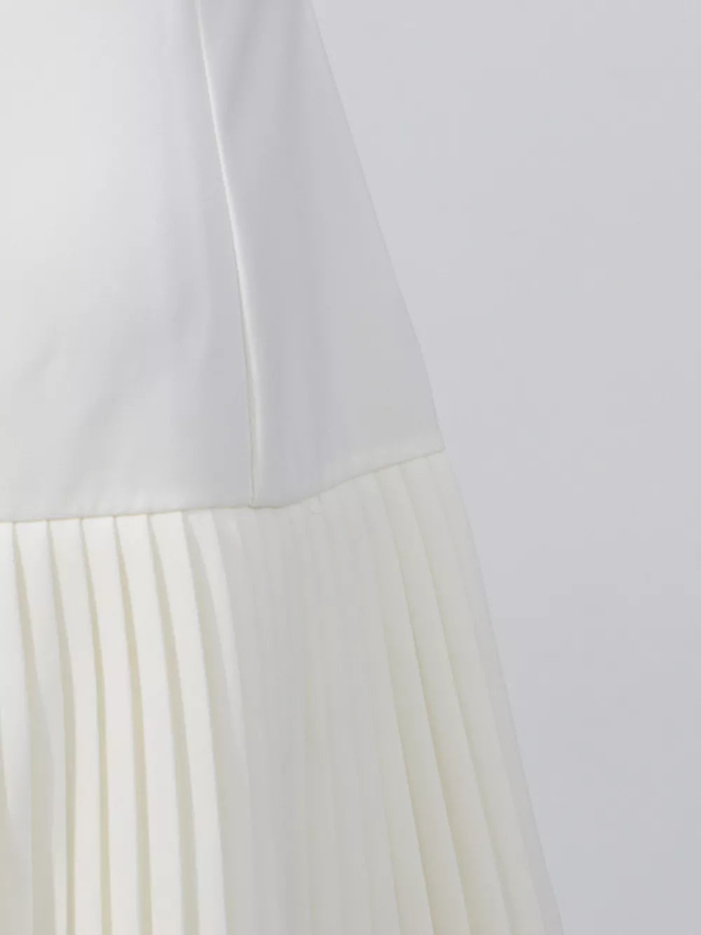 White mini dress with square neck and pleated skirt detail