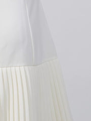 White mini dress with square neck and pleated skirt detail