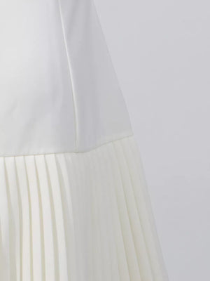 White mini dress with square neck and pleated skirt detail