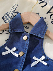 Denim halter top with white bow accents and gold buttons