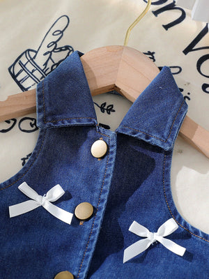 Denim halter top with white bow accents and gold buttons