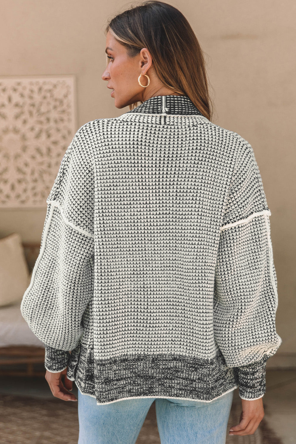 Textured open-front knit cardigan in black and cream with a waffle knit pattern and contrasting hem.