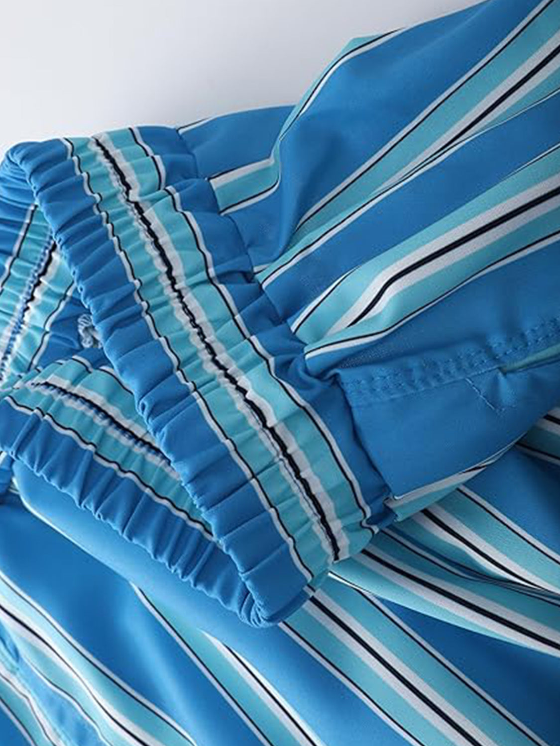 Blue striped shorts with elastic waistband and drawstring detail.