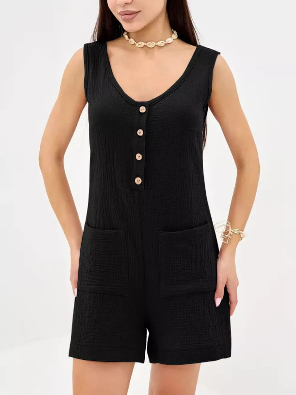 Black cotton crinkled button-down sleeveless romper with patch pockets.
