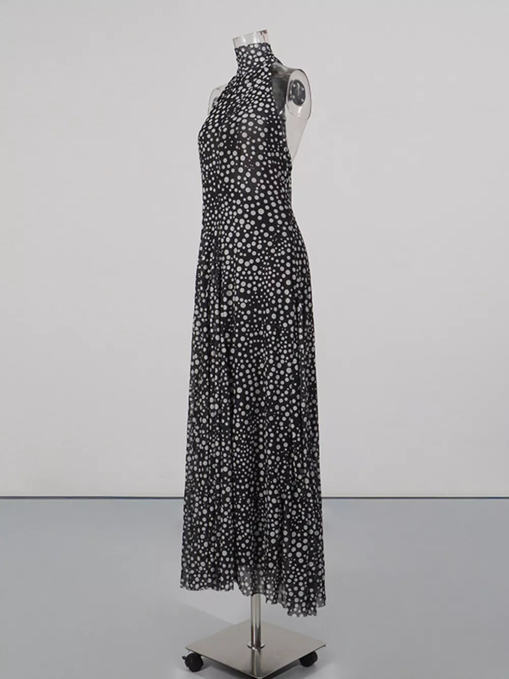 Black and white polka dot halter maxi dress with a flowing skirt.