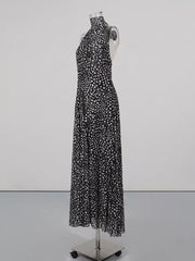 Black and white polka dot halter maxi dress with a flowing skirt.