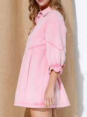 Blush pink denim button-down dress with ruffled cuffs and a flared skirt.