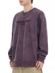 Purple oversized sweatshirt with "Imperfection Is Beauty" graphic print and crew neck.
