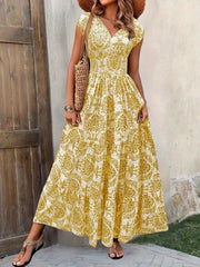 Yellow damask print maxi dress with cap sleeves and tiered skirt.