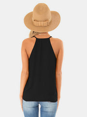 Black draped crossover halter cami with thin straps and a relaxed fit.