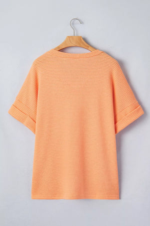 Waffle knit t-shirt in sherbet orange with cuffed short sleeves and a V-neck.
