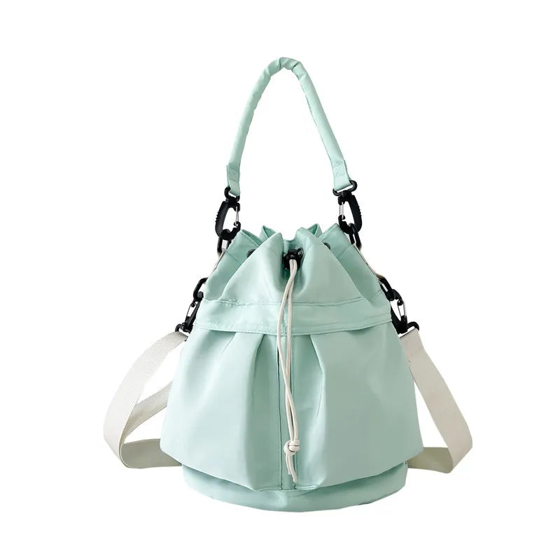 Light green nylon drawstring bucket bag with chain detail and white strap