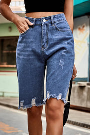 Medium wash denim bermuda shorts with frayed hem and distressed details.