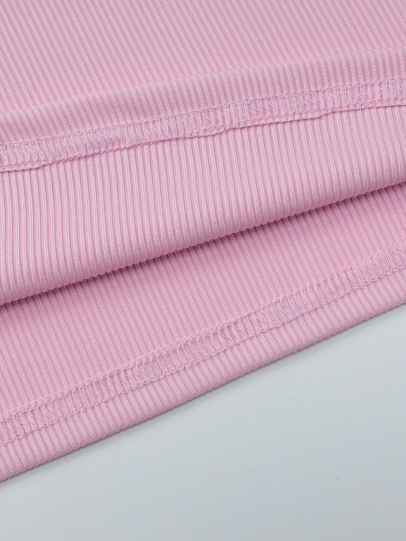 Buttoned ribbed long sleeve top in dusty pink with visible stitching detail.