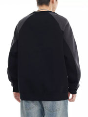 Black oversized sweatshirt with raglan sleeves and contrasting gray panels.