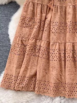 Light brown eyelet tiered maxi skirt with cutout details and drawstring waist.