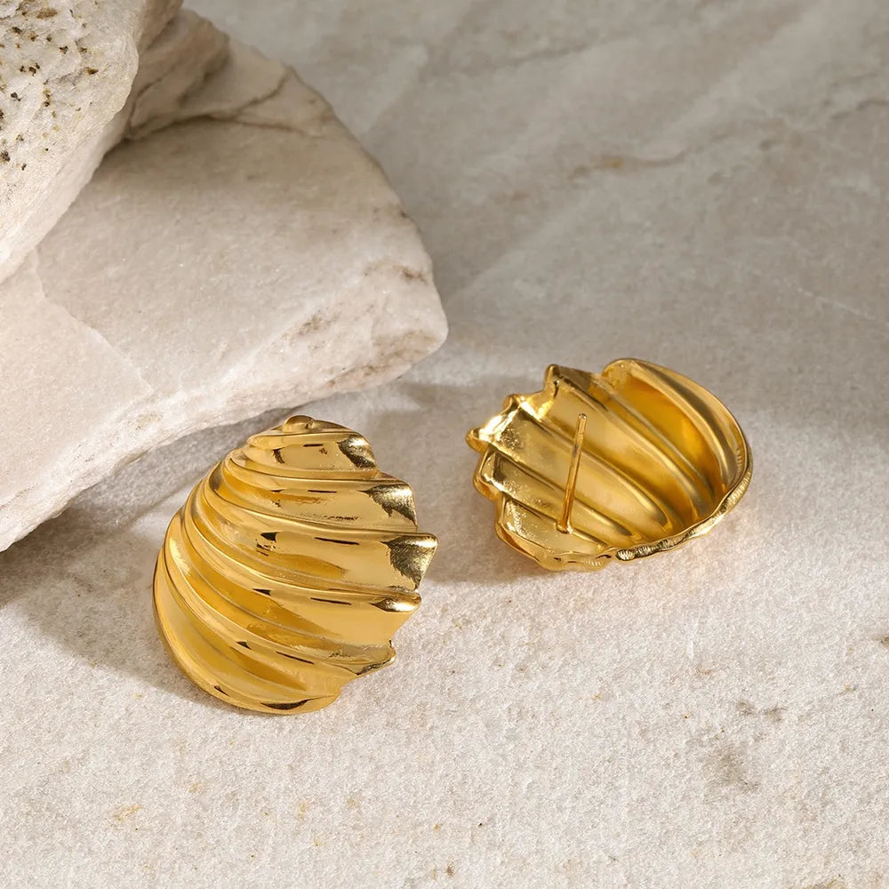 Sculpted spiral gold stud earrings with textured detail.