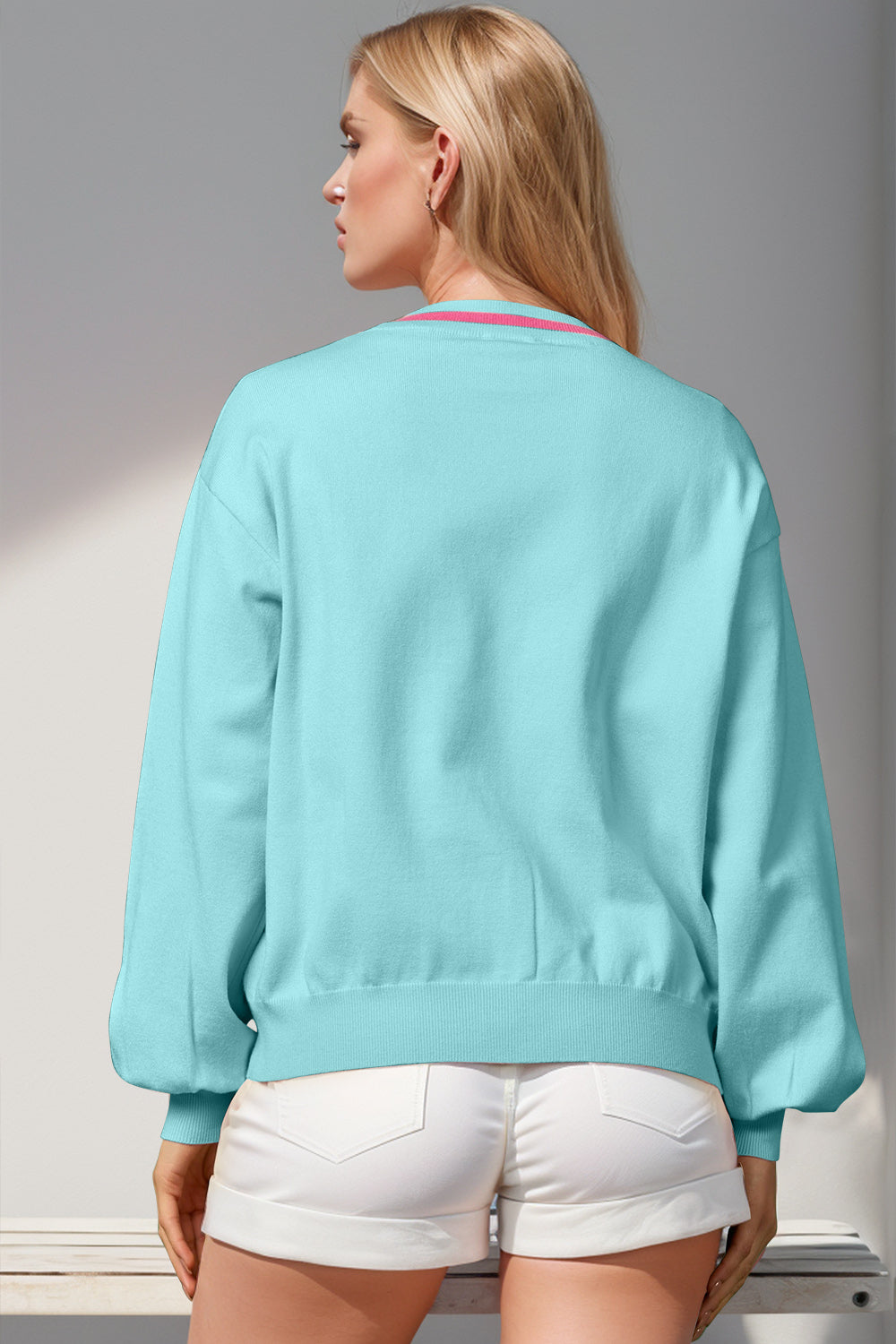 Cerulean acrylic cardigan with pink trim neckline and balloon sleeves.