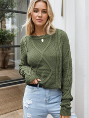 Moss green acrylic cable knit cropped sweater with textured diamond pattern.