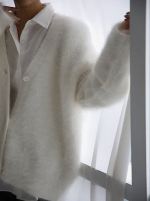 White angora buttoned cardigan with sculpted sleeves over a white collared shirt.