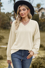 Beige cable knit V-neck pullover sweater with textured pattern and long sleeves.