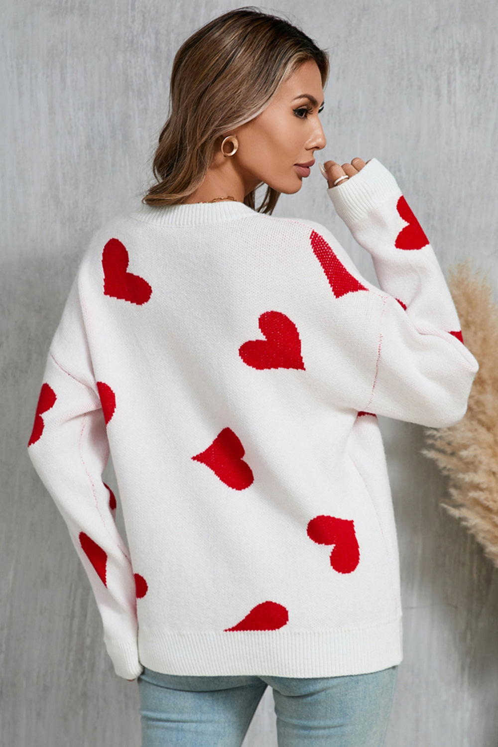 White acrylic knit jumper with red heart intarsia pattern, crew neck, long sleeves.