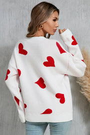 White acrylic knit jumper with red heart intarsia pattern, crew neck, long sleeves.
