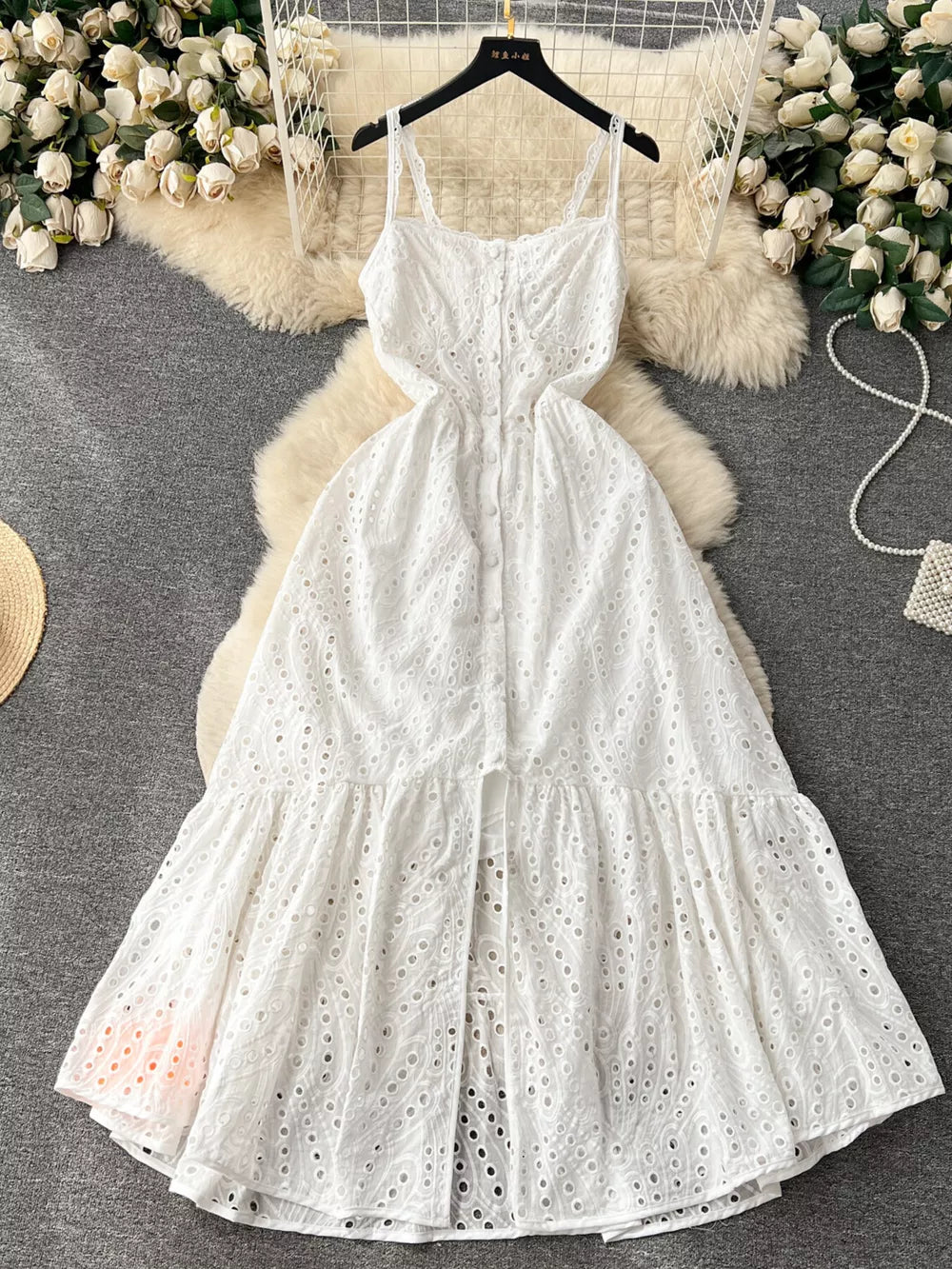 White lace-embroidered cami dress with tiered skirt and cutout details.