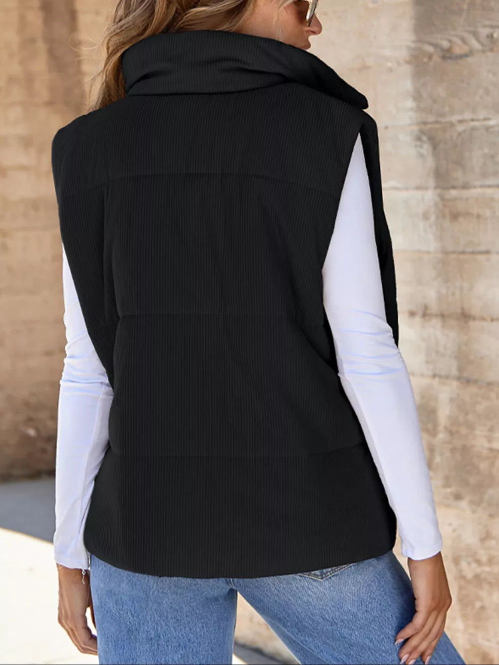 Black ribbed corduroy zip-up vest coat with high collar and quilted detail.