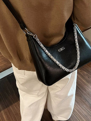 Black crossbody bag with silver chain detail and logo accent