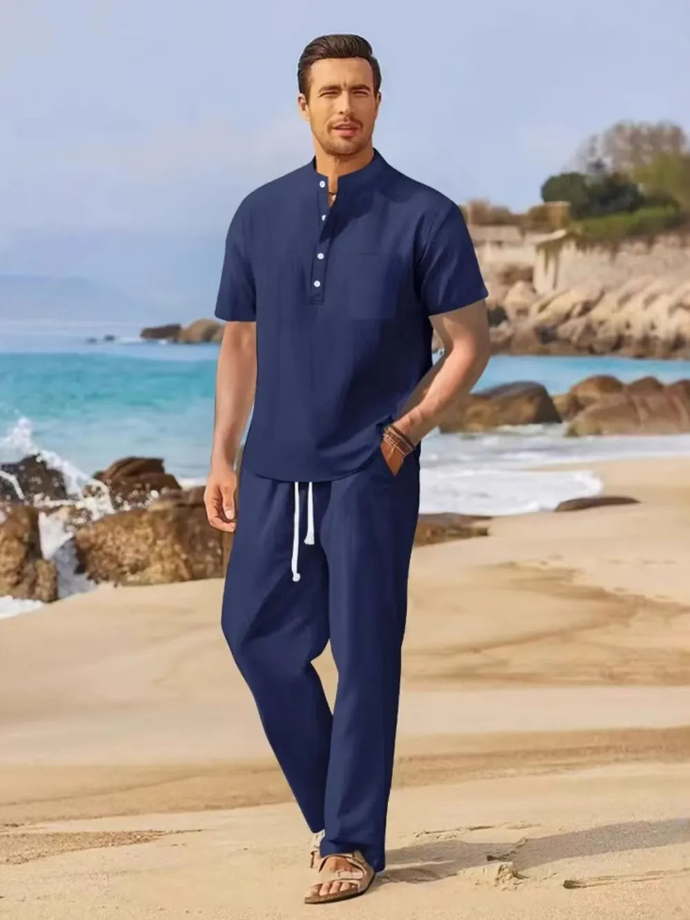 Navy linen henley shirt and drawstring trousers set on a beach
