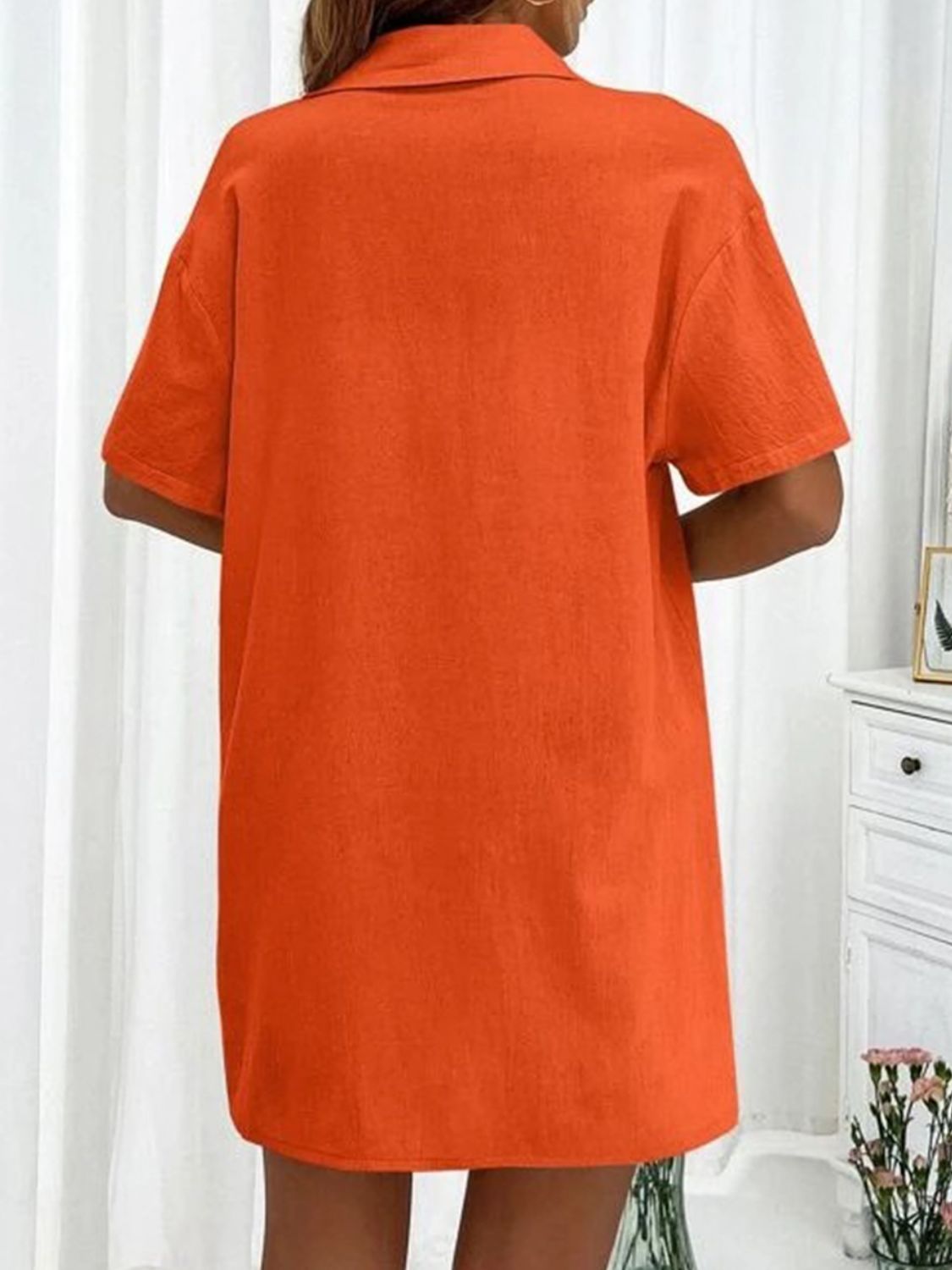 Orange linen shirt with short sleeves and collar, shown from the back.