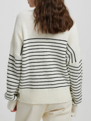 Cream ribbed knit sweater with black horizontal stripes and a half-zip neckline.