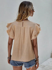 Khaki blouse with ruffle sleeves trimmed with pom-poms and a keyhole back detail.